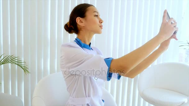Молодая привлекательная женщина-врач делает селфи с мобильного телефона . — стоковое видео