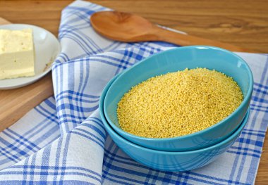 Millet mavi bir fincanda peçete ve tereyağlı bir tabakta inliyor.