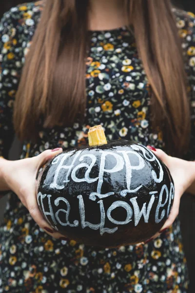 Decoration for Halloween. A girl holding a pumpkin in the hands — Stock Photo, Image