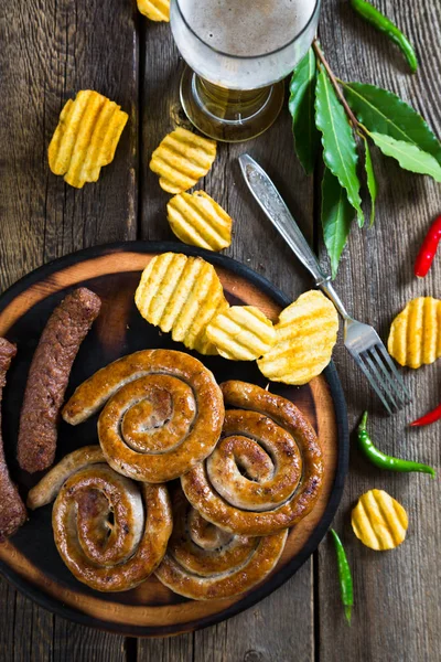Sült kolbász, burgonya chips és a sör — Stock Fotó