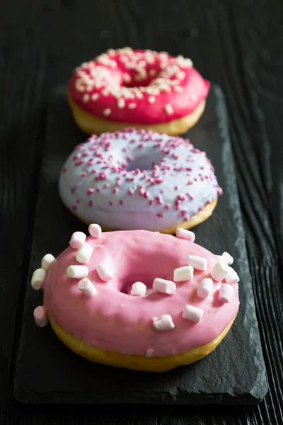 Три разноцветных пончика — стоковое фото