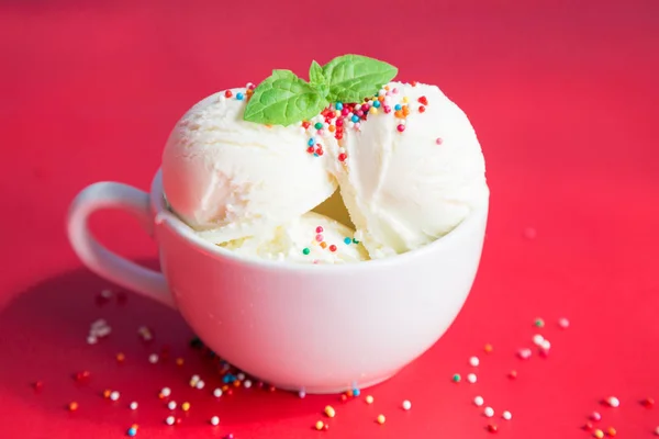 Мороженое в чашке на красном фоне — стоковое фото