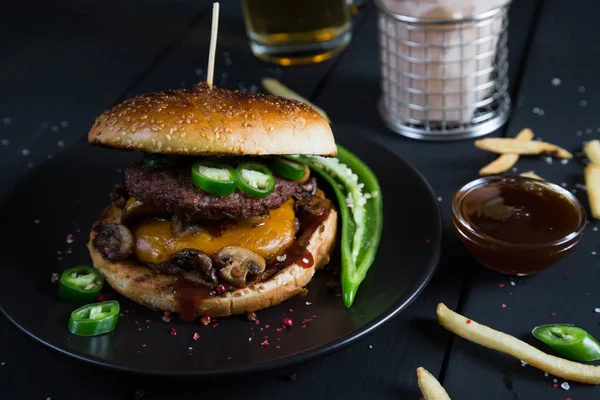 Cheeseburger with jalapeno pepper, French fries and beer