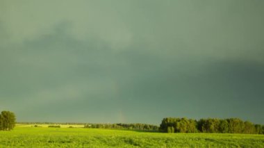 Bir fırtına günbatımı, bir gökkuşağı görünümünü sırasında. Zaman sukut manzara