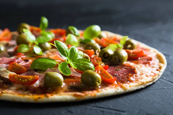 Pizza sobre una masa fina con aceitunas y albahaca fresca —  Fotos de Stock