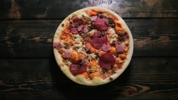 Torcendo pizza em um fundo de madeira — Vídeo de Stock