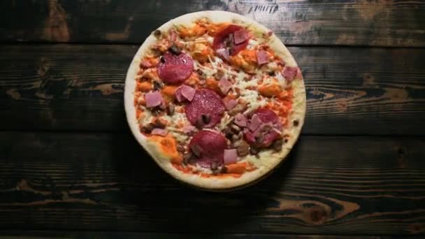 Pizza auf einem hölzernen Hintergrund drehen — Stockvideo