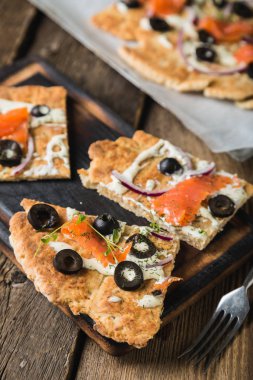 Füme alabalık, zeytin ve soğanlı düz ekmek.