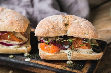 Somon, zeytin ve kremalı sarımsak soslu sandviç.