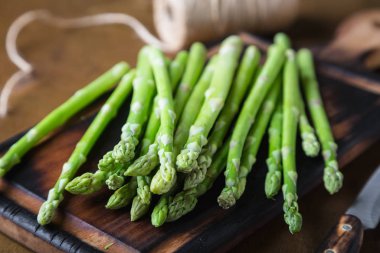 Tahta bir masada taze kuşkonmaz.