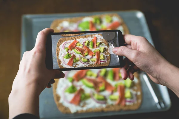 Food blogger photographs food on a smartphone camera