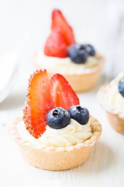 Taze dutlu kekler. Çilekli kremalı tart ve yaban mersini.