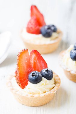 Taze dutlu kekler. Çilekli kremalı tart ve yaban mersini.