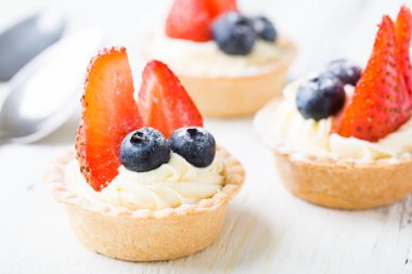 Taze dutlu kekler. Çilekli kremalı tart ve yaban mersini.