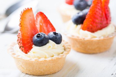 Taze dutlu kekler. Çilekli kremalı tart ve yaban mersini.