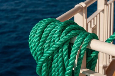 Denizin arka planında sarmalanmış yeşil halat