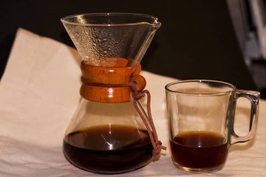 15.01.2020. Kiev, Ukrayna. Koyu ve taze siyah kahve arap kahveli Chemex hafif kaba kumaşın üzerinde duruyor. Alternatif bira yolu. Süzgeç.