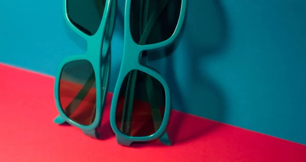 Jasně Růžovém Pozadí Leží Sluneční Brýle Plastovém Modrém Rámu Tmavými — Stock fotografie