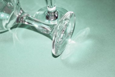 Pembe arka planda cam şeffaf şarap kadehleri. Tabaklardaki gölgeler ve gölgeler.
