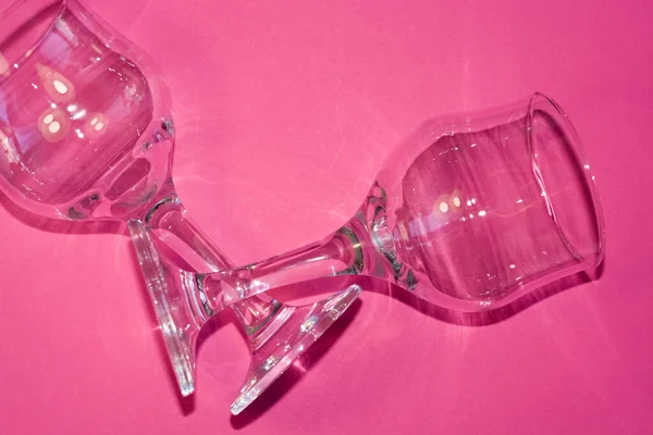玻璃透明酒杯 腿上的粉红色背景 菜上的亮点和阴影 — 图库照片