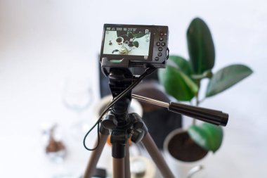 Kameraya beyaz arkaplanda kahve hazırlama işleminin üç ayağı üzerinde video kaydediliyor..