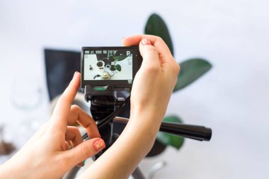 Kameraya beyaz arkaplanda kahve hazırlama işleminin üç ayağı üzerinde video kaydediliyor..