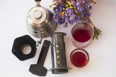 Beyaz arka plan, sert, sabah, özel kahve. Aletten alternatif bir yöntemle demlenmiş. Çiçek buketi ve cam eşyalar..