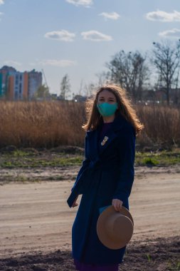 Cerrahi mavi maskeli bir kadın hava kirliliği veya virüs koronavirüsü salgını nedeniyle korunuyor.. 