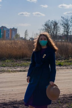 Cerrahi mavi maskeli bir kadın hava kirliliği veya virüs koronavirüsü salgını nedeniyle korunuyor.. 