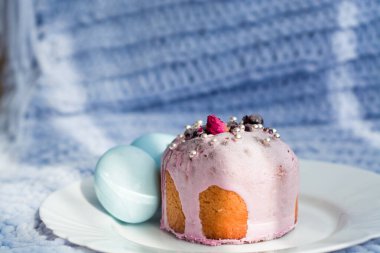 Paskalya ekmeği, çiçekler, boncuklar ve fındıklı kek ve yumurta. Mavi örülmüş ekose. Paskalya bayramı ve dekor konsepti..