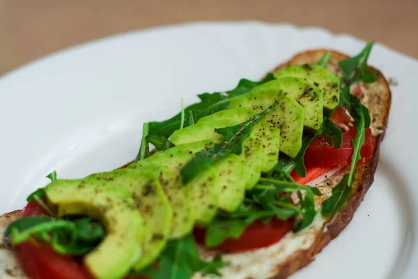 Toast Ciemnego Chleba Awokado Pomidorami Rukolą Zdrowa Żywność Śniadanie Świeżych — Zdjęcie stockowe