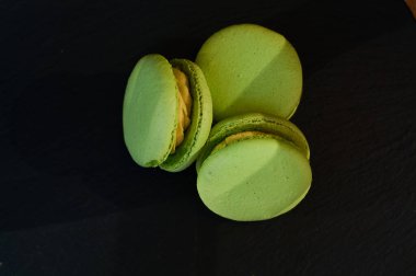 Siyah bir tonluk arka plan ve limonlu yeşil Fransız kekleri..