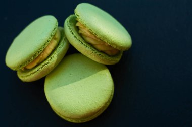 Siyah bir tonluk arka plan ve limonlu yeşil Fransız kekleri..