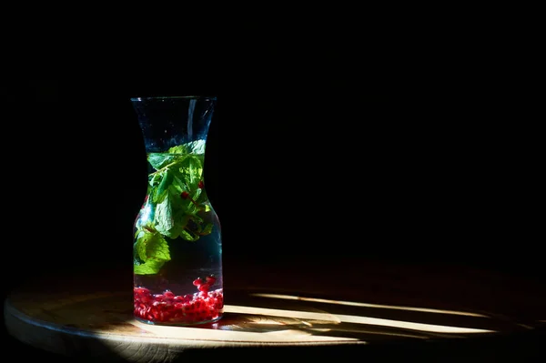 黒の背景とガラスは ミントとザクロ豆と飲み物は 太陽の光の反対側に立っている 便利な水 — ストック写真