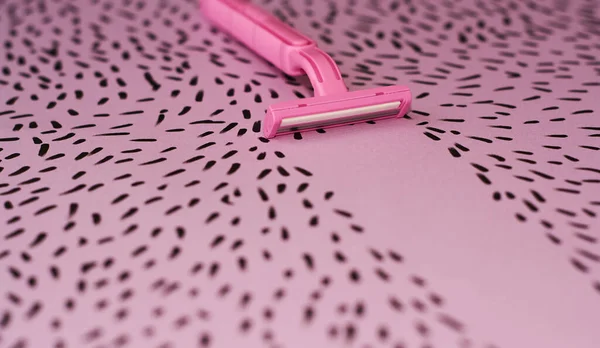 Pink background with marker drawn hairs and female razor for depilation.