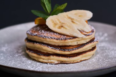 Portakal, muz, nane ve şeker tozuyla süslenmiş ev yapımı krep kahvaltısı..