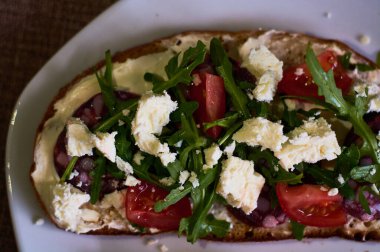 Peynir, roka, vişneli domates ve sosisli büyük boy çavdar ekmeği..