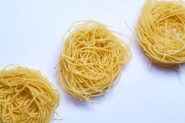 Beyaz arka plan ve ince İtalyan eriştesi, spagetti, buğday makarnası, çiğ.