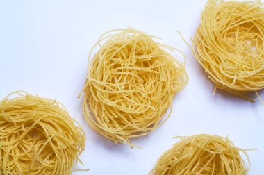 Beyaz arka plan ve ince İtalyan eriştesi, spagetti, buğday makarnası, çiğ.