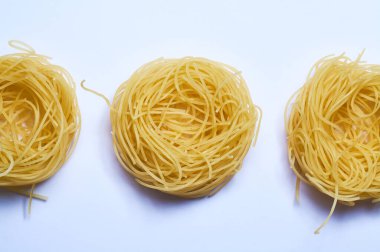 Beyaz arka plan ve ince İtalyan eriştesi, spagetti, buğday makarnası, çiğ.