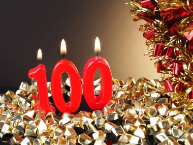 Nr. 100 gösterilen doğum günü Yıldönümü mum. Yanan kırmızı mum bir yıldönümü veya doğum günü arka plan için iyi.