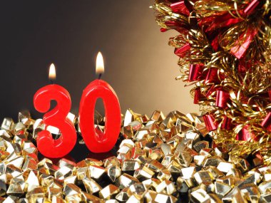 Nr. 30 gösterilen doğum günü Yıldönümü mum. Yanan kırmızı mum bir yıldönümü veya doğum günü arka plan için iyi.