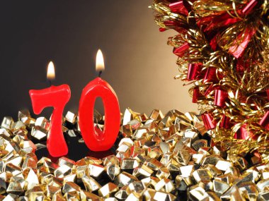 Nr. 70 gösterilen doğum günü Yıldönümü mum. Yanan kırmızı mum bir yıldönümü veya doğum günü arka plan için iyi.