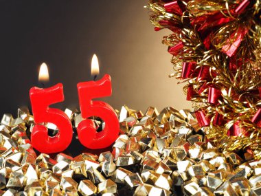 Nr. 55 gösterilen doğum günü Yıldönümü mum. Yanan kırmızı mum bir yıldönümü veya doğum günü arka plan için iyi.