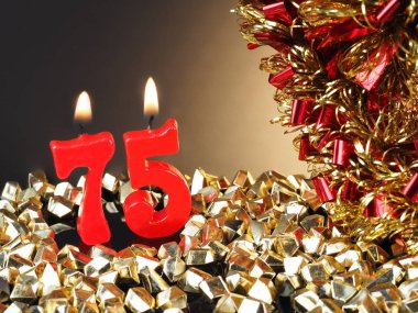 Nr. 75 gösterilen doğum günü Yıldönümü mum. Yanan kırmızı mum bir yıldönümü veya doğum günü arka plan için iyi.