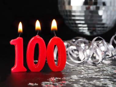 Nr. 100 gösterilen kırmızı mumlar. Doğum günü veya yıldönümü partisi için arka plan.