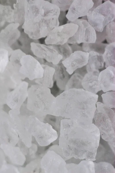 Translucent pieces of salt, transparent sand. Blocks of ice, macro photo of sea salt, cold, transparent background.