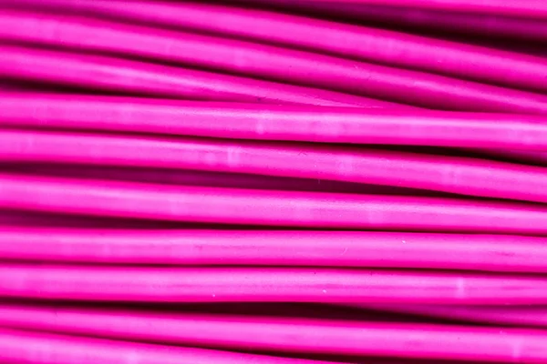 Pink wire, the coil of plastic in the macro. Close-up of a strip of plastic in a reel of turquoise color.