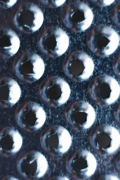 Closeup of a kitchen grater. Kitchen grater close-up, pattern