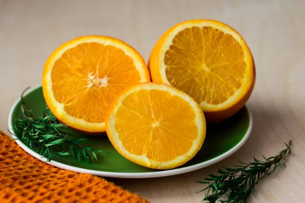 Oranges cut into slices lie on a green plate